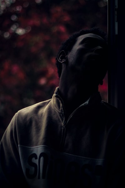 男人靠在玻璃窗
